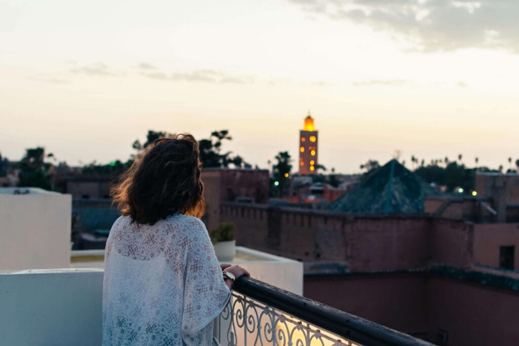 A breathtaking panoramic view of Morocco's iconic tourist attractions, captured under a warm, golden hour sun. In the foreground, the distinct minarets and intricate architecture of the Hassan II Mosque in Casablanca stand tall, contrasted by the vibrant blue hues of the Atlantic Ocean. In the middle ground, the iconic Koutoubia Mosque in Marrakech towers above the bustling medina, its ornate details bathed in soft, diffused light. In the distance, the majestic Atlas Mountains rise up, their snow-capped peaks creating a dramatic backdrop. The overall scene conveys the rich cultural heritage, architectural wonders, and natural beauty that define Morocco as a must-visit destination for first-time travelers. Top Morocco Tourist Attractions